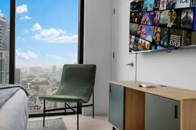 a bedroom with a green chair in front of a window at On 46th Floor! Amazing Views and Free Parking in Miami