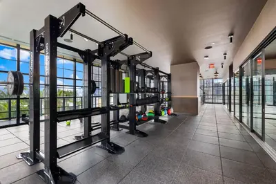 a gym with rows of equipment in a building at Stunning Condo with Free Parking on 46th Floor! in Miami