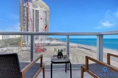 a balcony with a view of the beach and the ocean at 1BR Apartment with Ocean View in Sunny Isles Beach