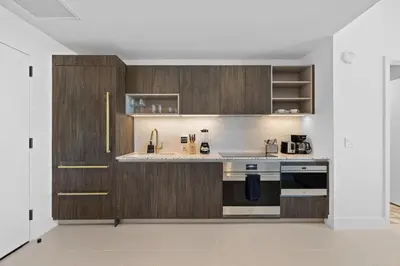 a kitchen with wooden cabinets and a stove top oven at 48Flr Condo w Free Parking in Miami