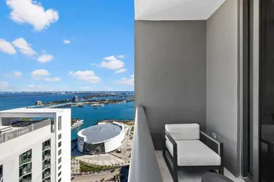 a balcony with a chair and a view of the water at 48Flr Condo w Free Parking in Miami