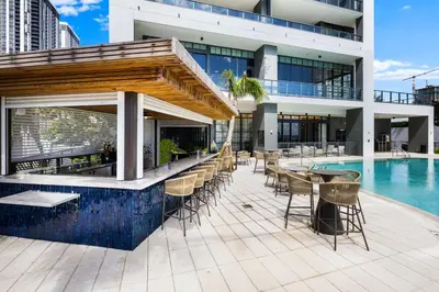 a building with a swimming pool and a patio with tables and chairs at 48Flr Condo w Free Parking in Miami
