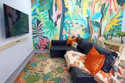 a living room with a black couch and a colorful mural at Rooftop Retreat on Ocean Drive with Beach View in Miami Beach