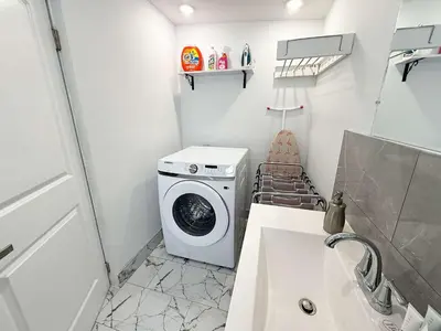 a small bathroom with a washing machine and a sink at Rooftop Retreat on Ocean Drive with Beach View in Miami Beach