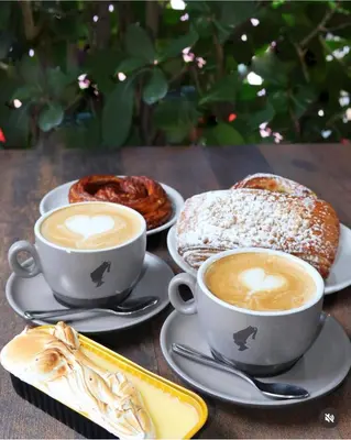 two cups of coffee and two pastries on a table at Milan Aventura Hotel in Aventura