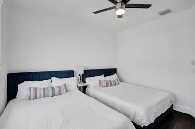 two beds sitting next to each other in a room at 4 BR Designer Home Next to Shul and Community Pool villa in Fort Lauderdale