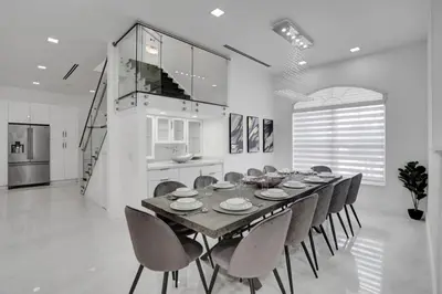 a dining room with a table and chairs and a kitchen at 4 BR Designer Home Next to Shul and Community Pool villa in Fort Lauderdale