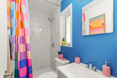 a bathroom with a colorful shower curtain and a toilet at Chic Getaway Near Wilton Drive l Your Urban Escape in Fort Lauderdale