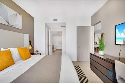 a bedroom with a large white bed with yellow pillows at Luxury 2BR Pools & Free Parking in Hollywood