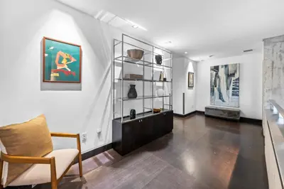 a living room with a chair and a shelf with vases at Villa Nova in Miami