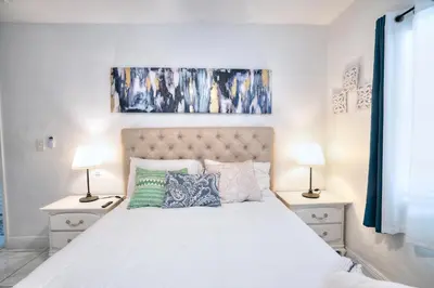 a bedroom with a large white bed with two lamps at Tropical Retreat in Miami Beach in North Miami Beach