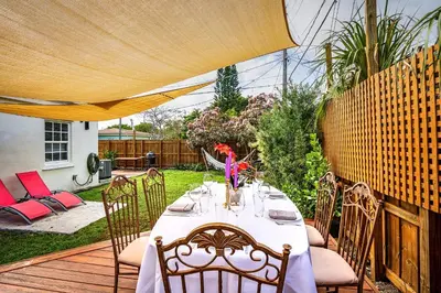 a table with chairs and a table umbrella on a patio at Tropical Retreat in Miami Beach in North Miami Beach