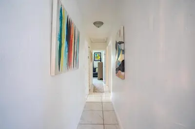 a hallway with three paintings on the walls at Tropical Retreat in Miami Beach in North Miami Beach