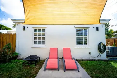 two red chairs sitting in front of a house at Tropical Retreat in Miami Beach in North Miami Beach