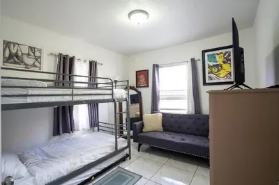 a bedroom with two bunk beds and a couch at Tropical Retreat in Miami Beach in North Miami Beach