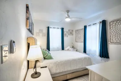 a bedroom with a bed and a table with a lamp at Tropical Retreat in Miami Beach in North Miami Beach