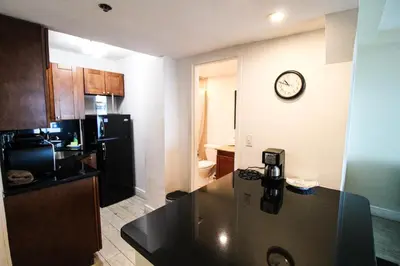 a kitchen with a counter and a clock on the wall at Castle 929 Stunning ocean view, pool, beach access, tennis, free parking in Miami Beach