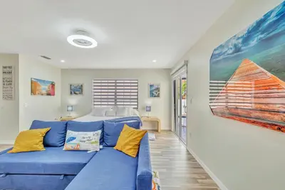 a living room with a blue couch and a bed at Dreams Studio in Hialeah
