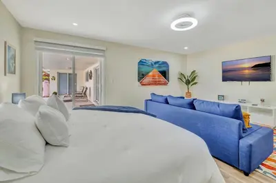 a bedroom with a large bed and a blue couch at Dreams Studio in Hialeah