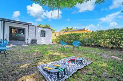 a backyard with a table and chairs and a house at Villa Roads - Ideal Stay in Miami - King - Bed Parking - Near Airport, Brickell, Coconut Grove, Little Havana, Wynwood & Calle 8 in Miami