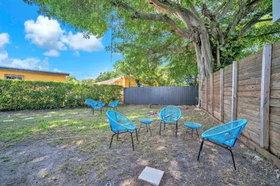 a group of chairs and tables in a yard at Villa Roads - Ideal Stay in Miami - King - Bed Parking - Near Airport, Brickell, Coconut Grove, Little Havana, Wynwood & Calle 8 in Miami
