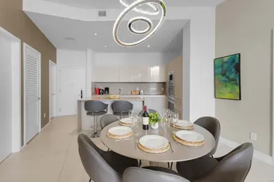 a white dining room with a table and chairs at 2BR Ocean View Balcony & Pool in Hollywood
