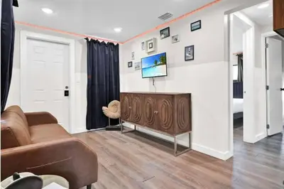 a living room with a couch and a tv on a wall at Stylish Miami Suites with Self Check-in in Miami