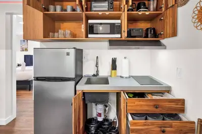 a kitchen with a stainless steel refrigerator and wooden cabinets at Stylish Miami Suites with Self Check-in in Miami