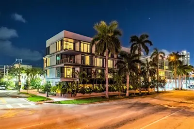a building with palm trees in front of a street at The March Hotel in Miami Beach