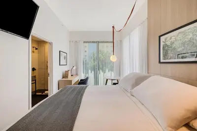 a bedroom with a large white bed and a desk at The March Hotel in Miami Beach