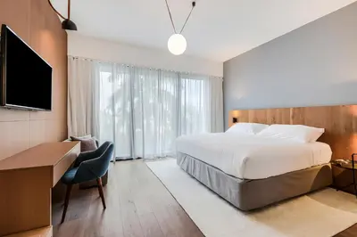 a bedroom with a bed and a desk and a television at The March Hotel in Miami Beach