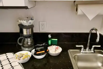 a kitchen counter with three measuring cups next to a sink at South of Fifth Studio Steps to Beach on Ocean Drive in Miami Beach