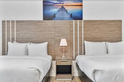 a hotel room with two beds and a picture of a pier at South of Fifth Studio Steps to Beach on Ocean Drive in Miami Beach