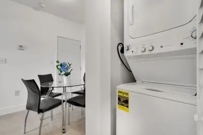a kitchen with a table with chairs and a microwave at Magical 2 BR Apartment 5 mins to Brickell Best Area in Miami in Miami