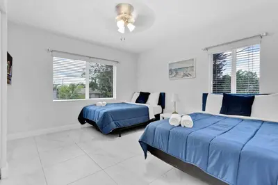 a white bedroom with two beds and a couch at Celeste House Enjoy Caribbean 2 BR APT in Miami