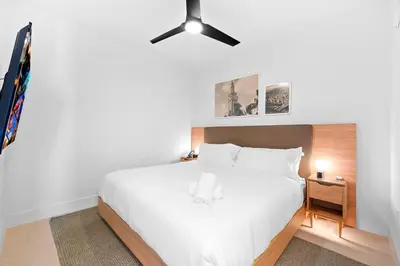a bedroom with a white bed with a ceiling fan at Luxury Condo on 44th Floor - Downtown Plus Parking in Miami