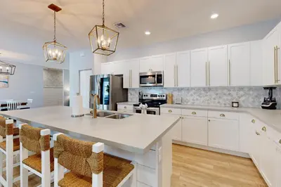 a kitchen with white cabinets and a large white island at Outdoor Oasis! Group-Friendly Miami Getaway in Burrs Strip