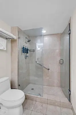 a bathroom with a glass shower with a toilet at Gallery One Resort Access Fort Lauderdale Beach in Fort Lauderdale