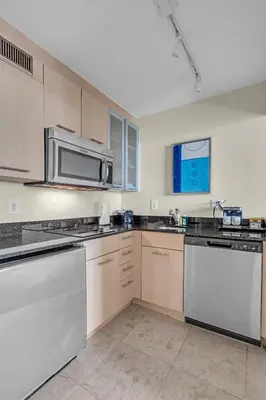 a kitchen with white appliances and a microwave at Gallery One Resort Access Fort Lauderdale Beach in Fort Lauderdale