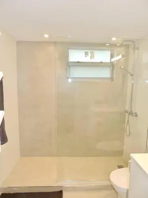 a bathroom with a shower and a toilet and a window at 2BR in Heart of SoBe with Parking in Miami Beach