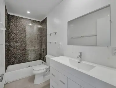 a white bathroom with a toilet and a sink at Casa Ocaso in Miami