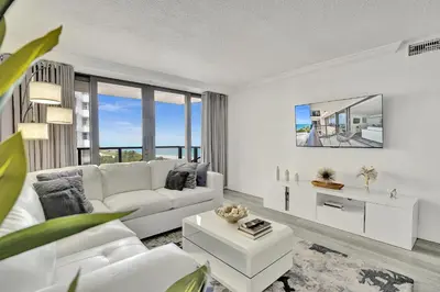 a living room with white furniture and large windows at Charming Ocean View Condo Beach Service 806 in Miami Beach