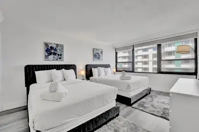 a bedroom with two beds and a large window at Charming Ocean View Condo Beach Service 806 in Miami Beach