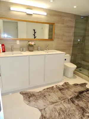 a bathroom with two sinks and a mirror and a toilet at Lux design 2 bedroom unit sleep 4 in SoBe bst area in Miami Beach