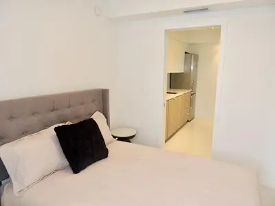 a bedroom with a white bed with a black pillow at Lux design 2 bedroom unit sleep 4 in SoBe bst area in Miami Beach