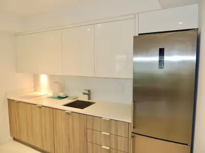 a kitchen with a stainless steel refrigerator and cabinets at Lux design 2 bedroom unit sleep 4 in SoBe bst area in Miami Beach