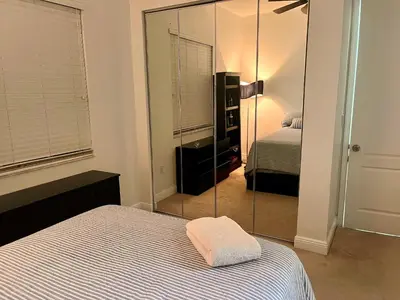 a bedroom with a mirror next to a bed at Fort Lauderdale Oasis private rooms in shared house in Fort Lauderdale