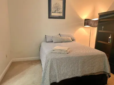 a bedroom with a bed with a striped blanket at Fort Lauderdale Oasis private rooms in shared house in Fort Lauderdale