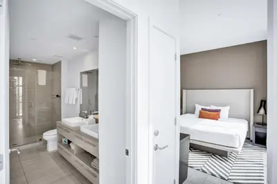 a white bedroom with a bed and a bathroom at Hollywood SkyView Penthouse in Hollywood