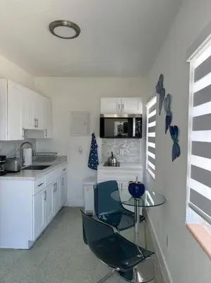 a kitchen with white cabinets and a glass table at Villa Clara Blue-Little Havana in Miami